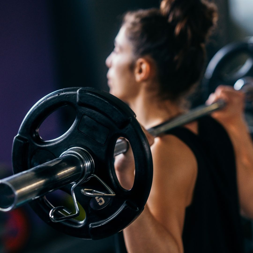 Woman lifting light weights at home to support PCOS and insulin resistance.